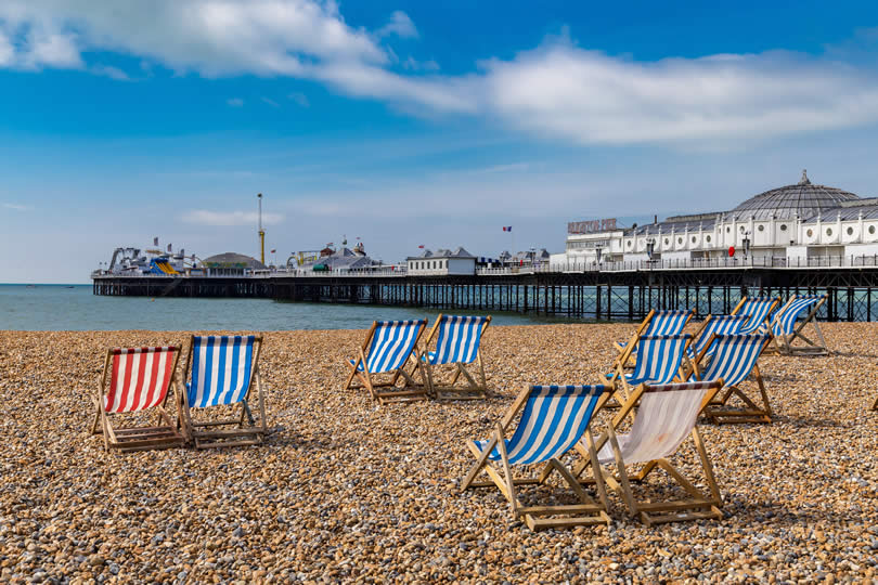 Brighton beach chairs and pier in background